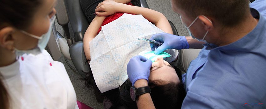 ADG-Dentist treating a patient`s teeth