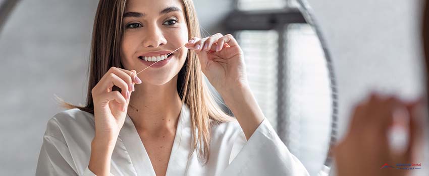 Smiling Young Female Using Dental Floss