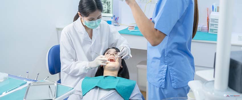 female dentist adjust dental surgical light